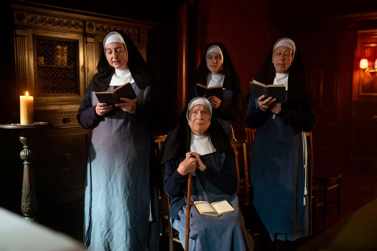 Call the Midwife's Sister Julienne holding a book and walking stick