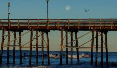 The Supermoon sets over surfers in California
