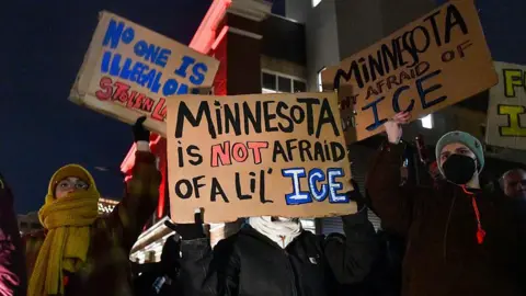 Getty Images Protesters hold signs that read "Minnesota is not afraid of a lil' ICE"