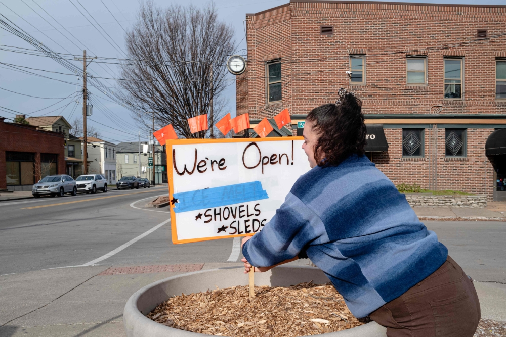 Caroline Cabezas places a sign in front of Keith's Hardware store on January 23, 2026 in Louisville, Kentucky as weather forecasts frigid temperatures, ice, and snow to nearly 200 million Americans. — Getty Images via AFP