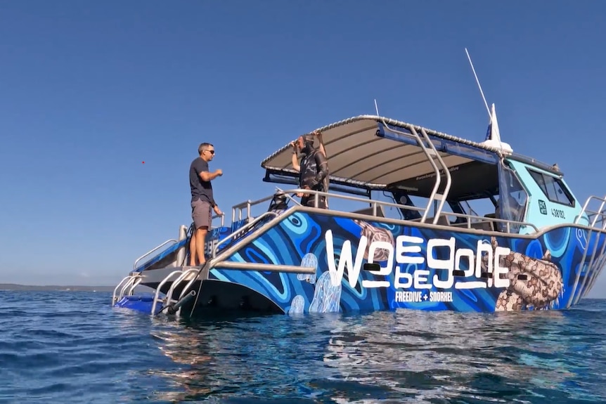 the boat on the water with two people standing on it