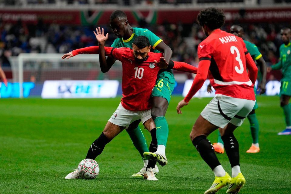 Egypt's Mohamed Salah is challenged by Senegal's Pape Gueye, rear, during the Africa Cup of Nations semifinal in Tangier, Morocco