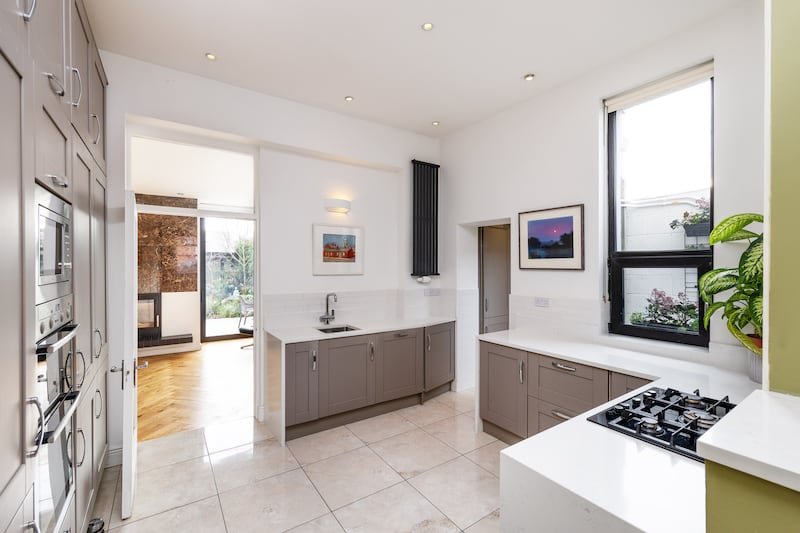 The kitchen is fitted with built-in Shaker-style grey units