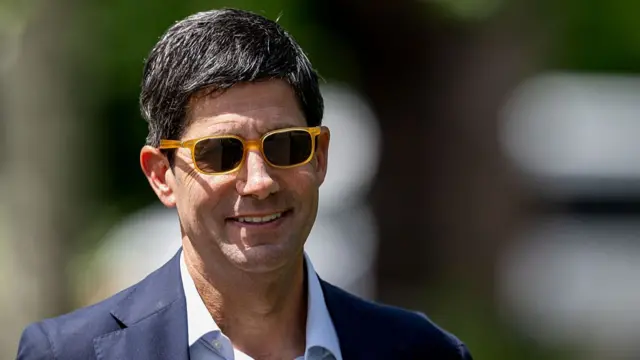 Kevin Warsh in sunglasses and a suit