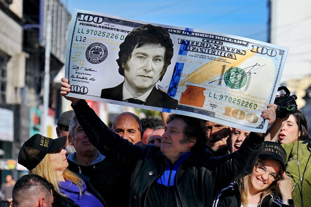 Then Argentine presidential candidate Javier Milei holds a giant 100-dollar bill with his face painted on it during a campaign rally in San Martin, Buenos Aires province, in 2023. Photo: AFP