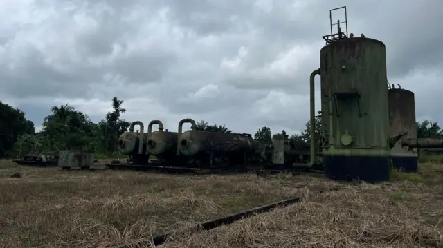 Parts of one abandoned flow station of Shell for K-Dere community in Ogoni land. E dey surrounded by small and dead vegetation.