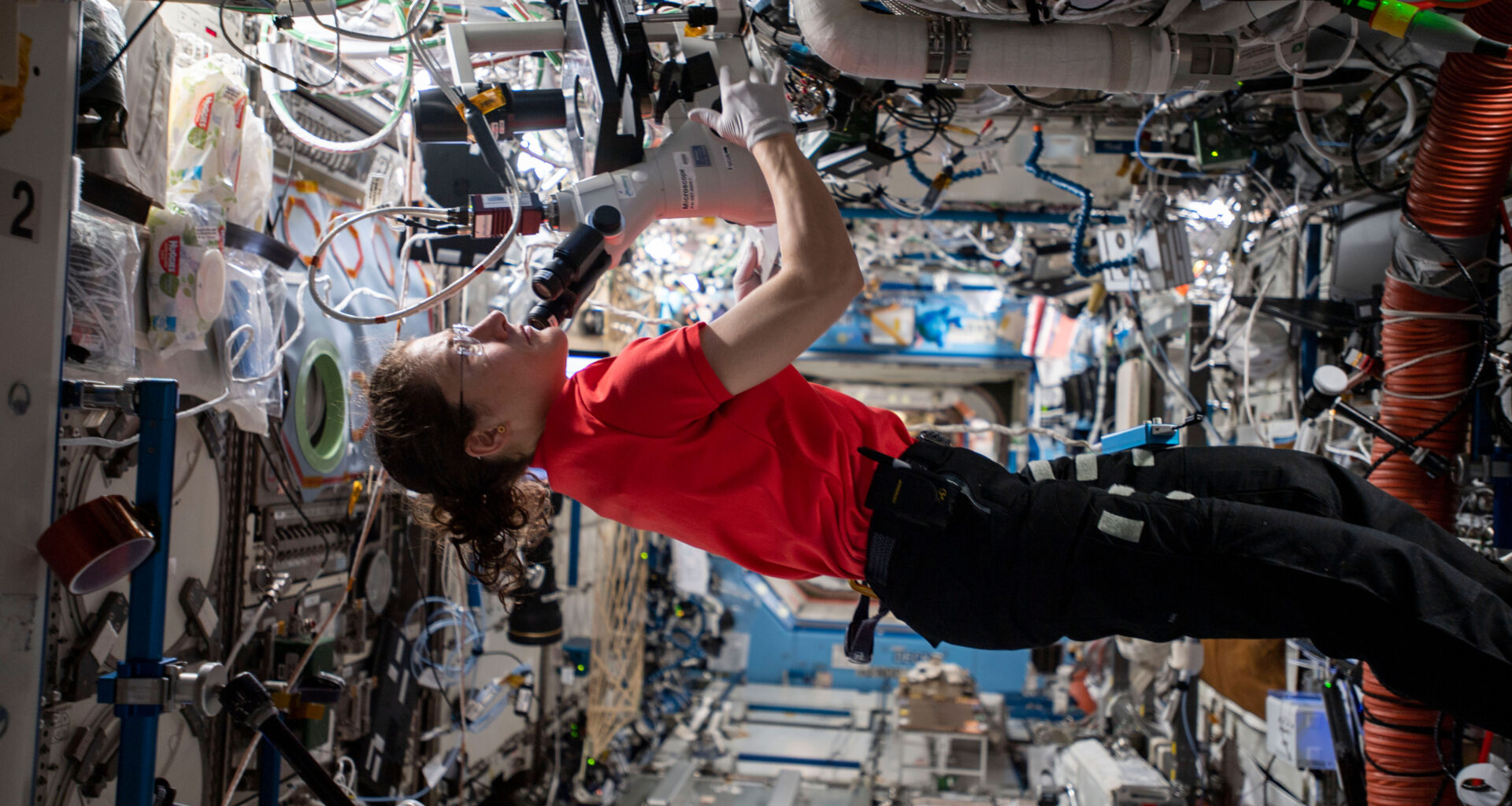 A woman conducts a research experiment aboard the International Space Station.