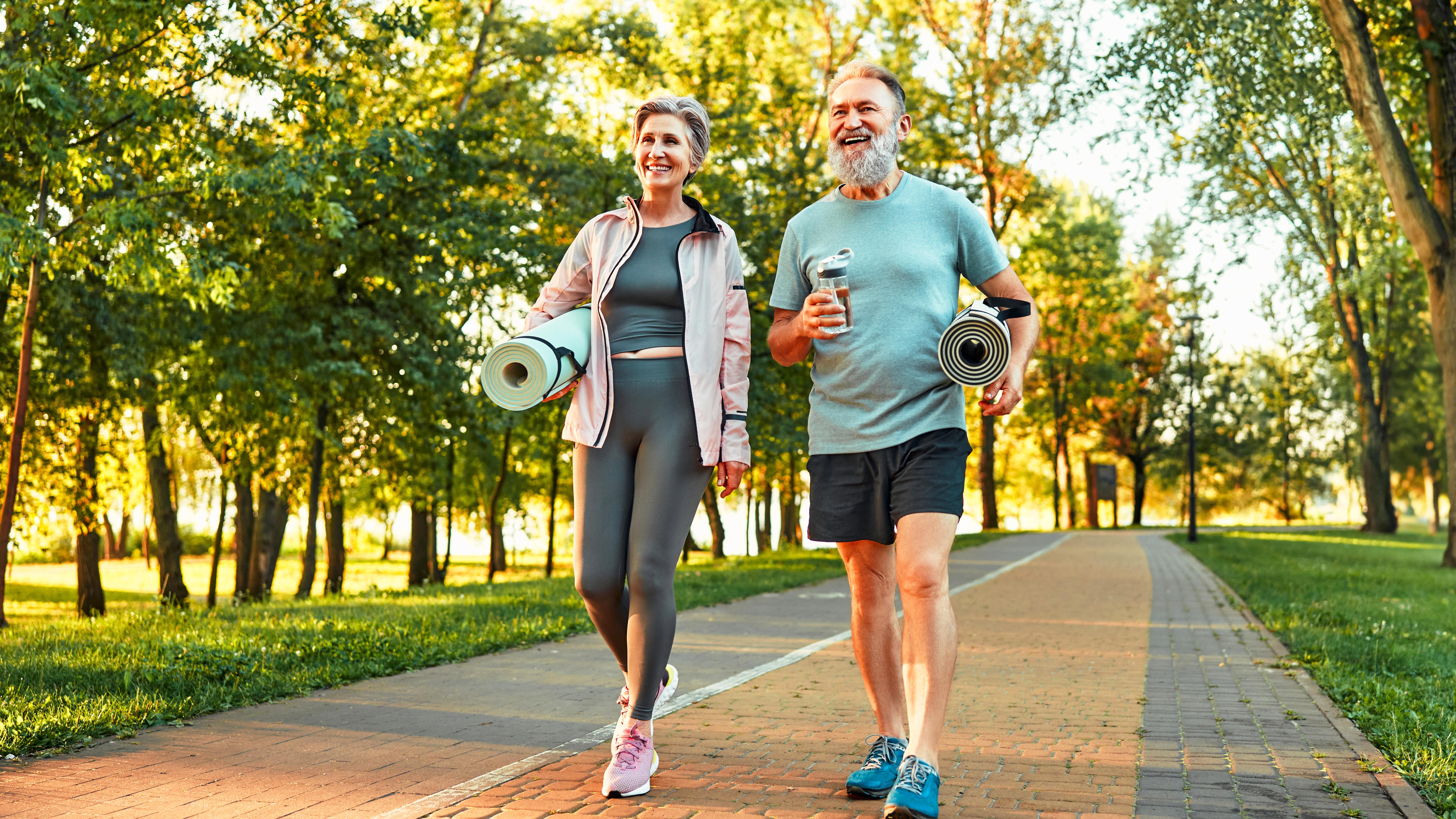 a senior couple carrying yoga mats