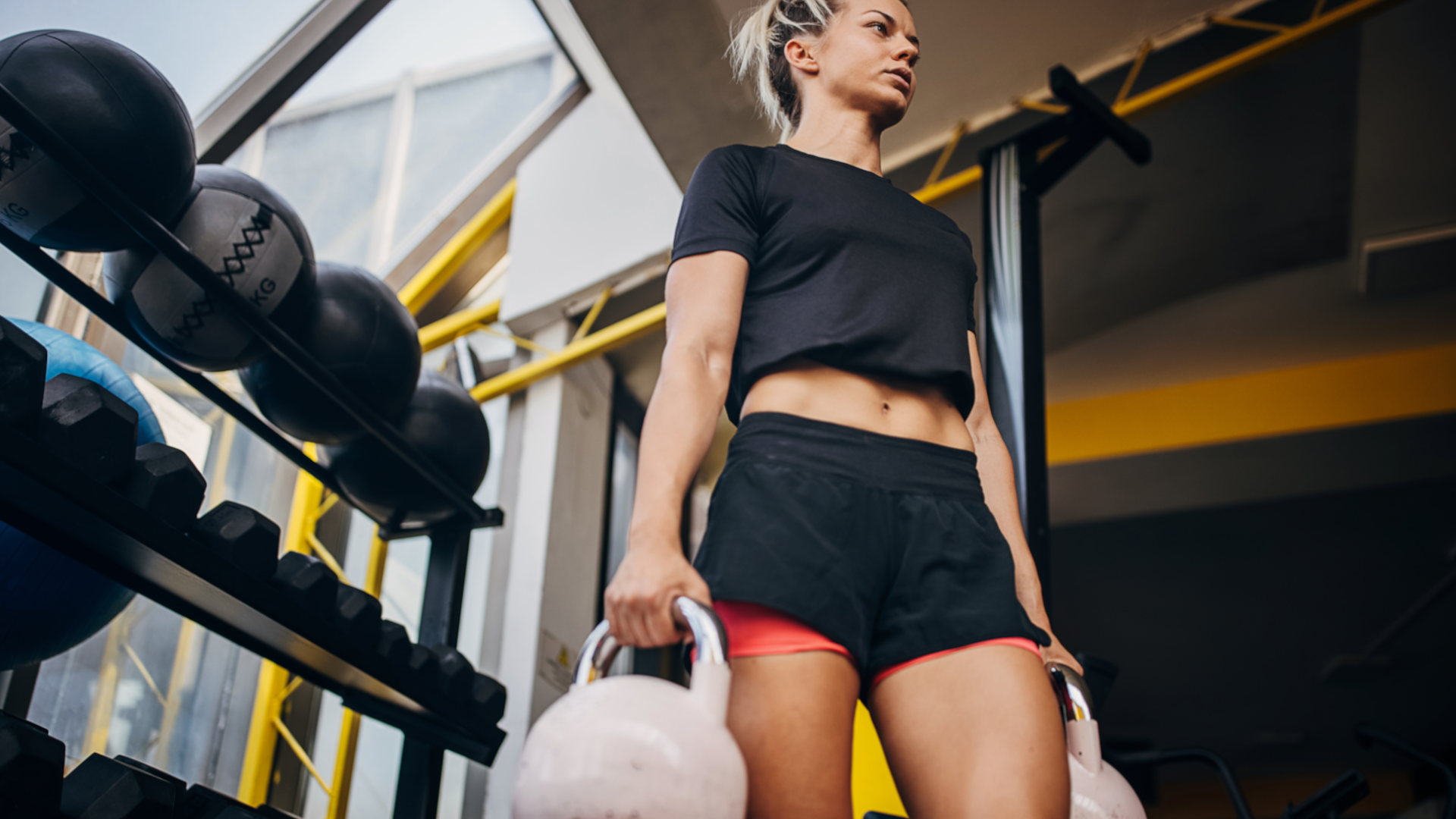 A woman performing kettlebell loaded carries