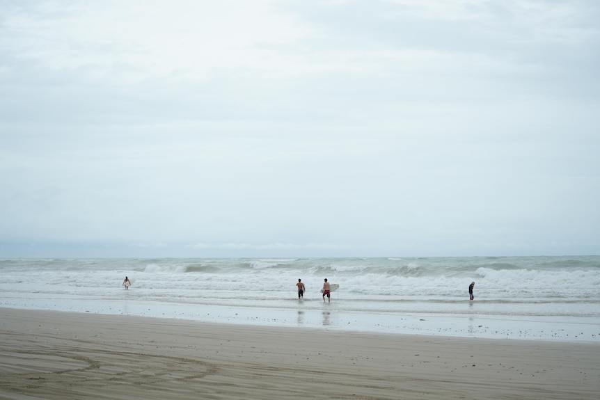Surfers walking into the ocean.