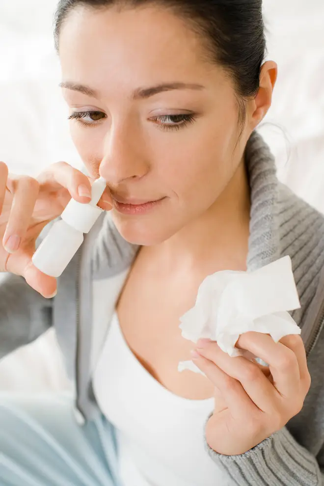 Woman applying nose spray