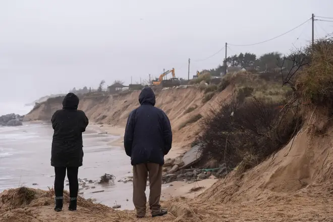 Local residents look on as properties are demolished close to the cliff edge at Hemsby in Norfolk, which are at risk of collapse as high tides cut into sandy cliffs