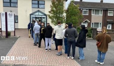A queue of dozens of people is formed outside a dentist's practice.