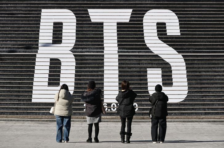 Tourists take a photo of a staircase promoting BTS' comeback in March at the Sejong Center for the Performing Arts in Seoul, Thursday. Yonhap