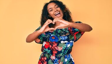 Smiling woman making a heart shape with her hands, representing heart health and cardiovascular wellness.