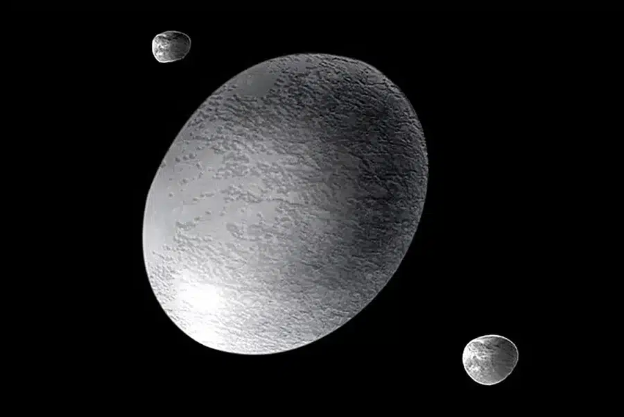 An Artist’s Impression Showing Haumea, A Bizarre, Rugby Ball Shaped Dwarf Planet, Along With At Least Two Moons And A Ring System.