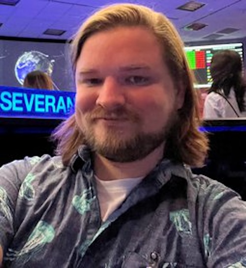 Smiling man with beard and moustache, wearing a shirt with jellyfish on it.