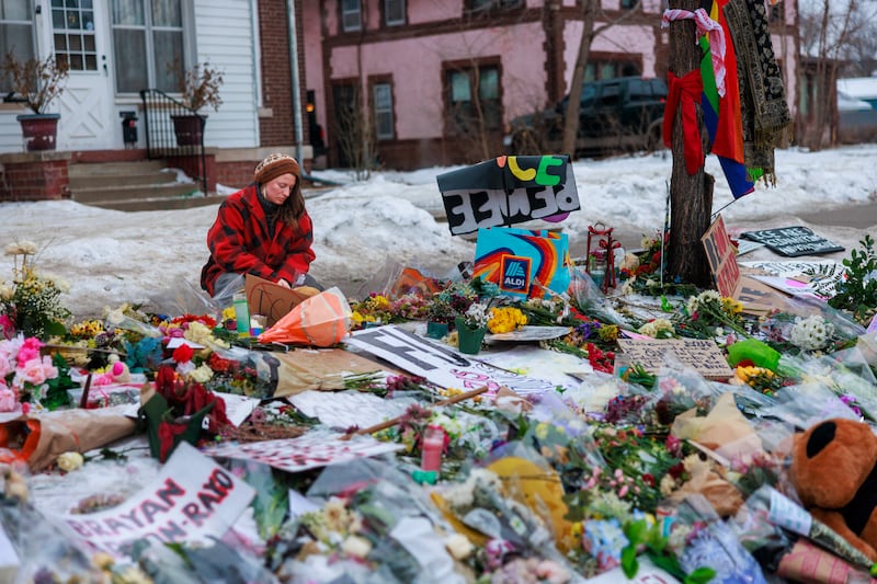 A woman visit a makeshift memorial honouring Renee Good and other victims of police and immigration enforcement violence outside a home along Portland Avenue South in Minneapolis, Minnesota, on Sunday. Photograph: Kerem Yucel/AFP via Getty