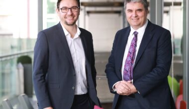 Two men in suits representing CeADAR pose in an office.