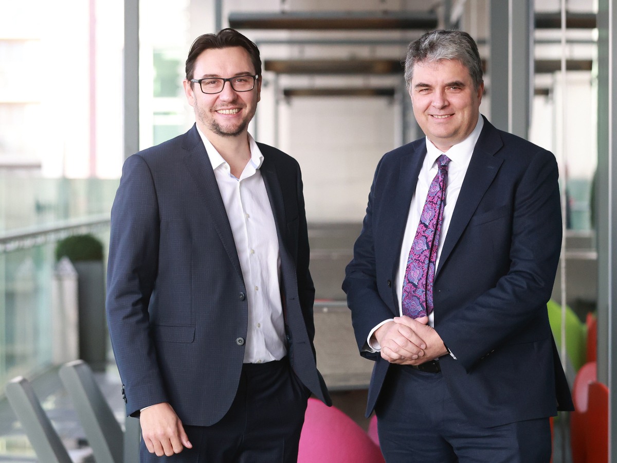 Two men in suits representing CeADAR pose in an office.