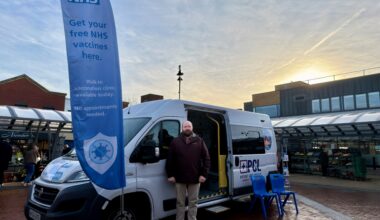 Image depicts Councillor Gary Flint standing outside a mobile vaccination van in Bloxwich.