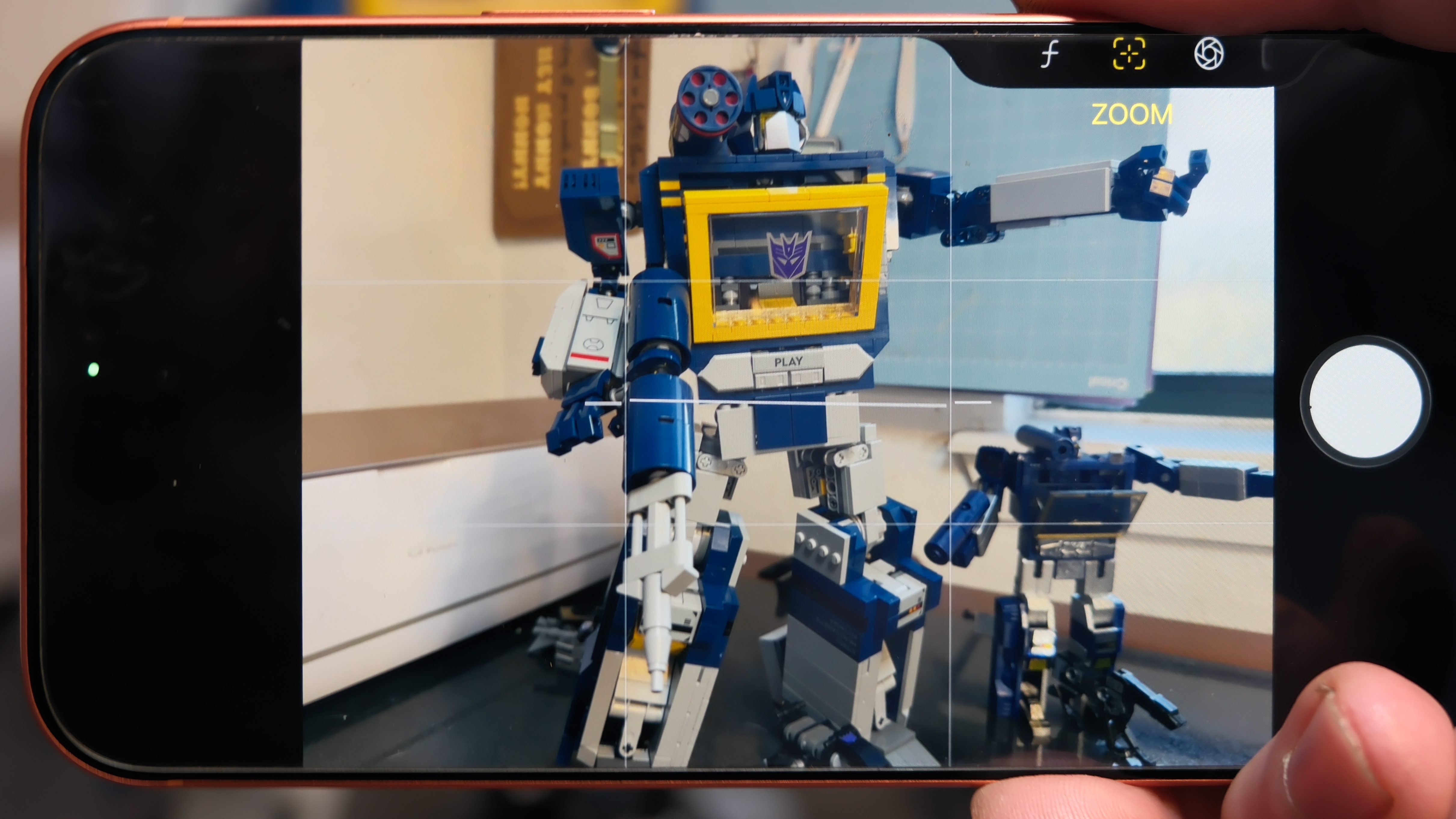 Camera Control button software features on the Apple iPhone 17 Pro Max in Cosmic Orange color, showing zoom, switching cameras, Magnifier app, and more