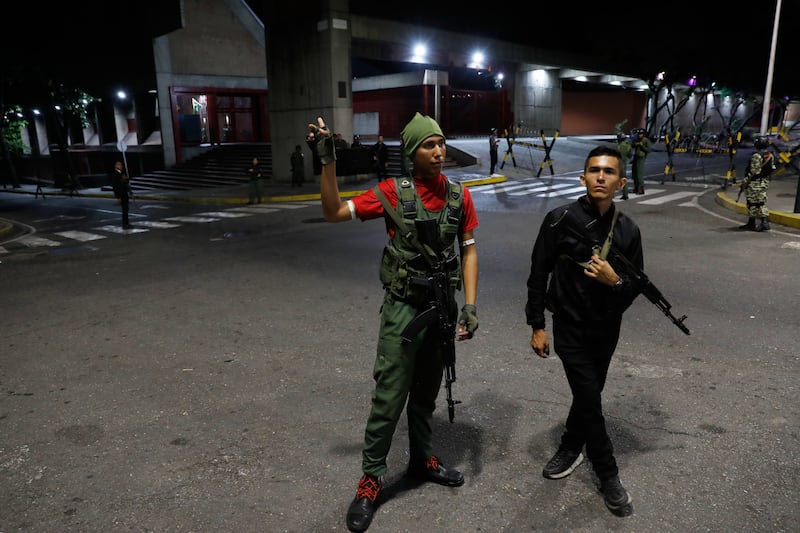 Members of the presidential guard stand outside the Miraflores presidential palace after the explosions were heard in Caracas. Photograph: Cristian Hernandez/AP