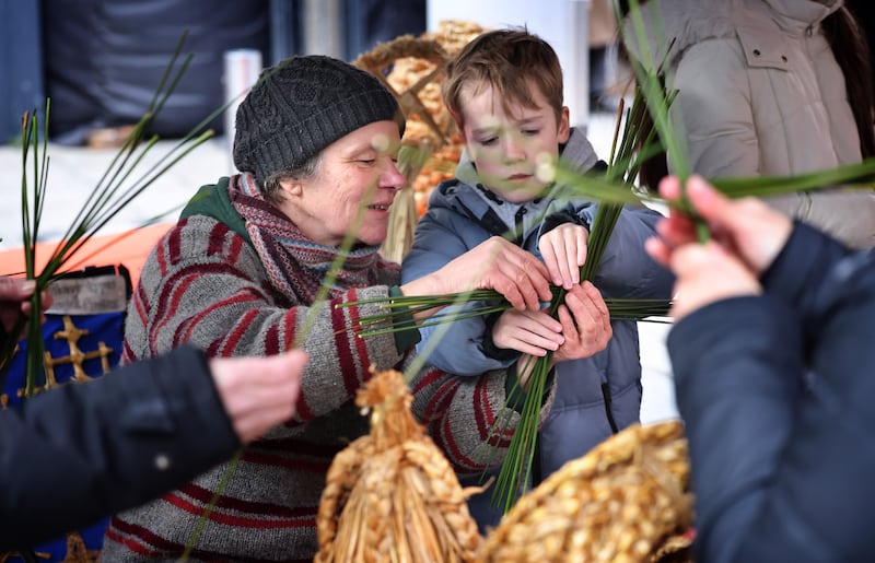 Steffi Otto, of Heritage Craft Alive in Leitrim, shows Dara Dunne, from Terenure, how to make a St Brigid’s Cross, at Brigit Imbolc Fair in Dublin. Photograph: Dara Mac Dónaill