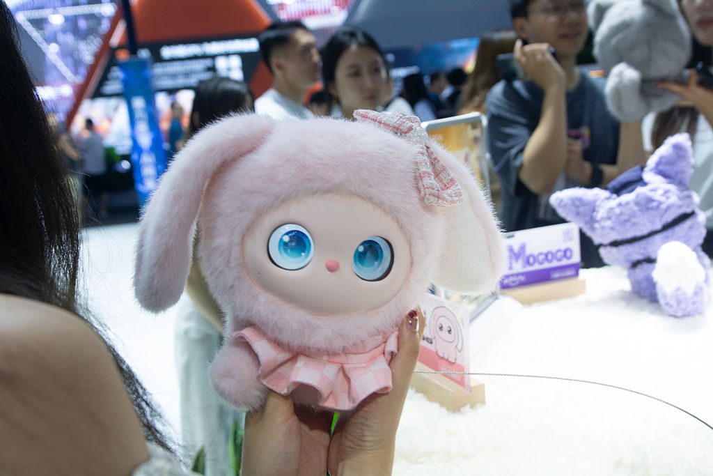 A general view shows fairgoers playing with an interactive doll at the Nubia booth at the Shanghai New Expo Center during the opening day of the World Artificial Intelligence Conference (WAIC) 2025 in Shanghai, China
