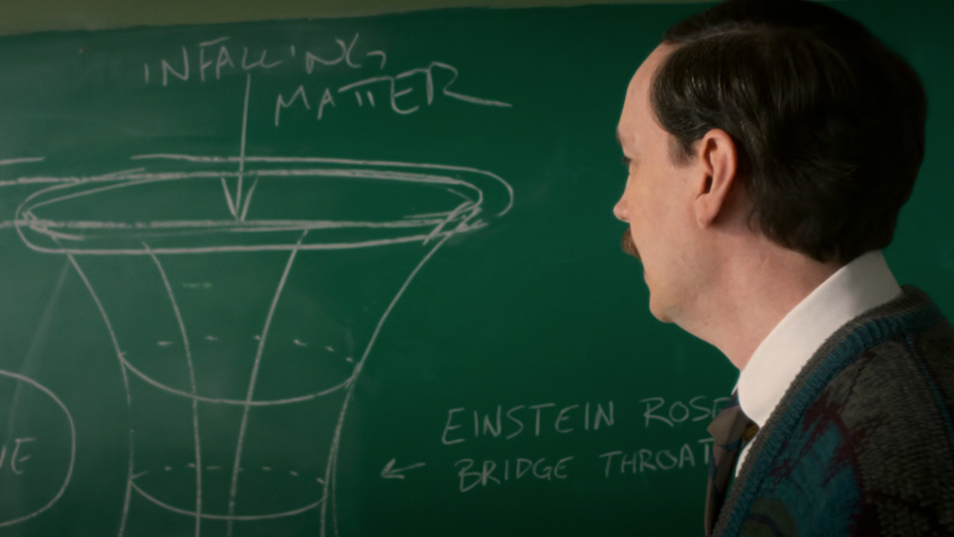 Screenshot from "Stranger Things" showing Mr Clarke teaching the kids about wormholes on a blackboard.