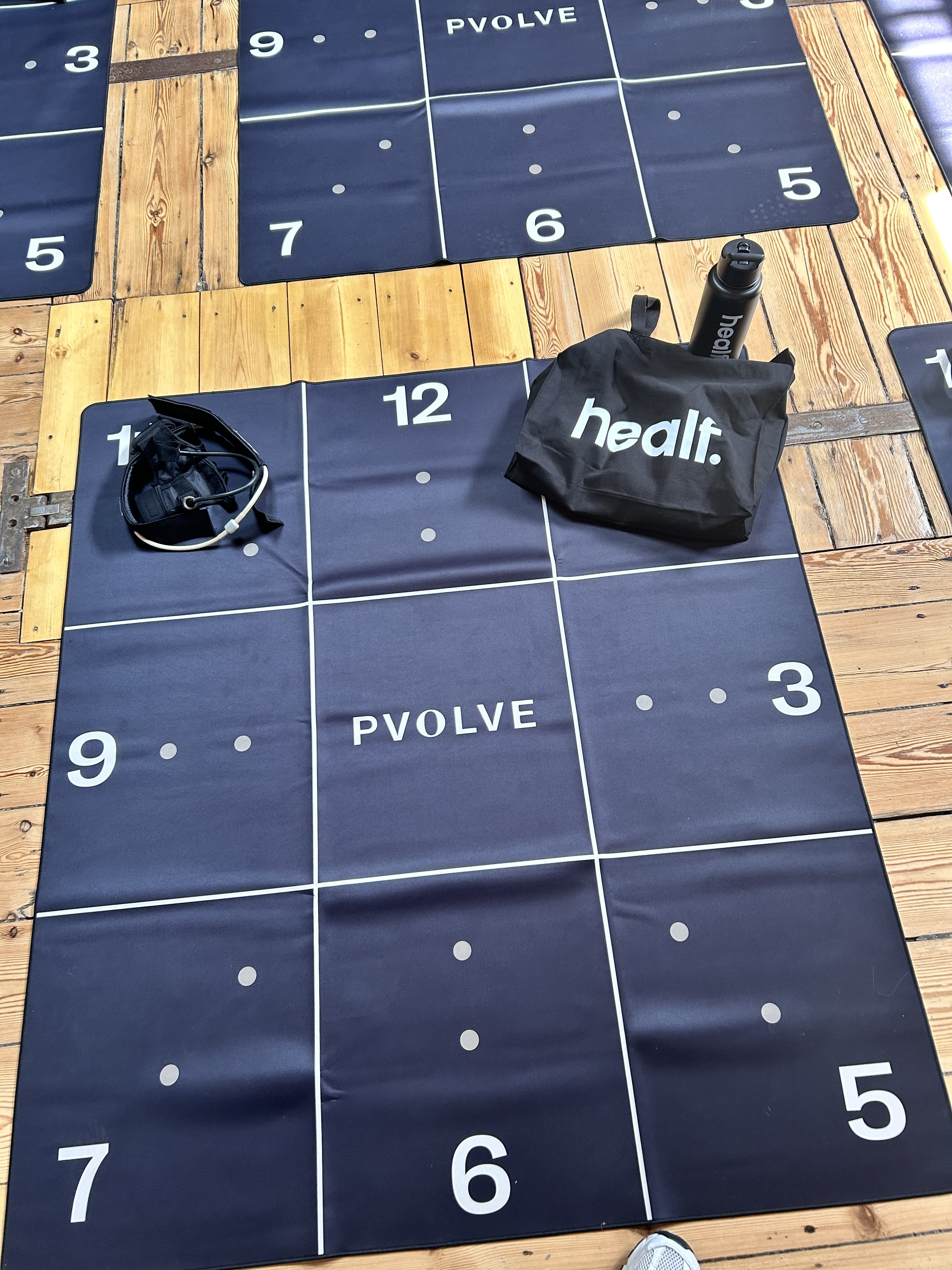 A Pvolve mat on a wooden floor.