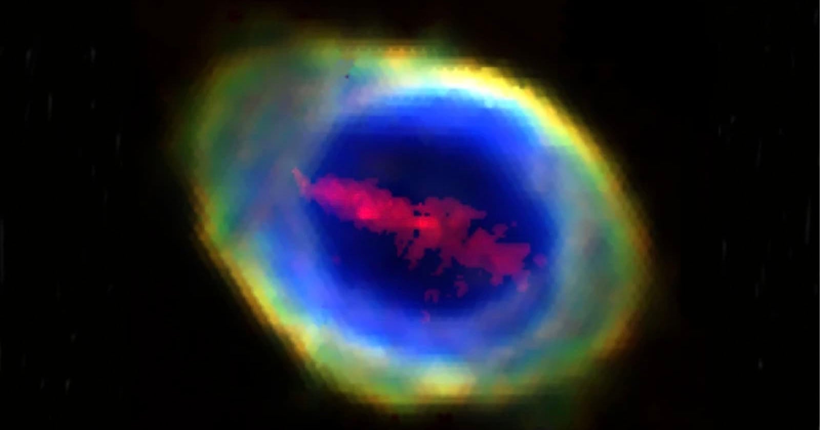 A glowing, colorful nebula with a bright yellow and green outer ring, a vivid blue center, and red cloud-like formations inside, set against a black background.