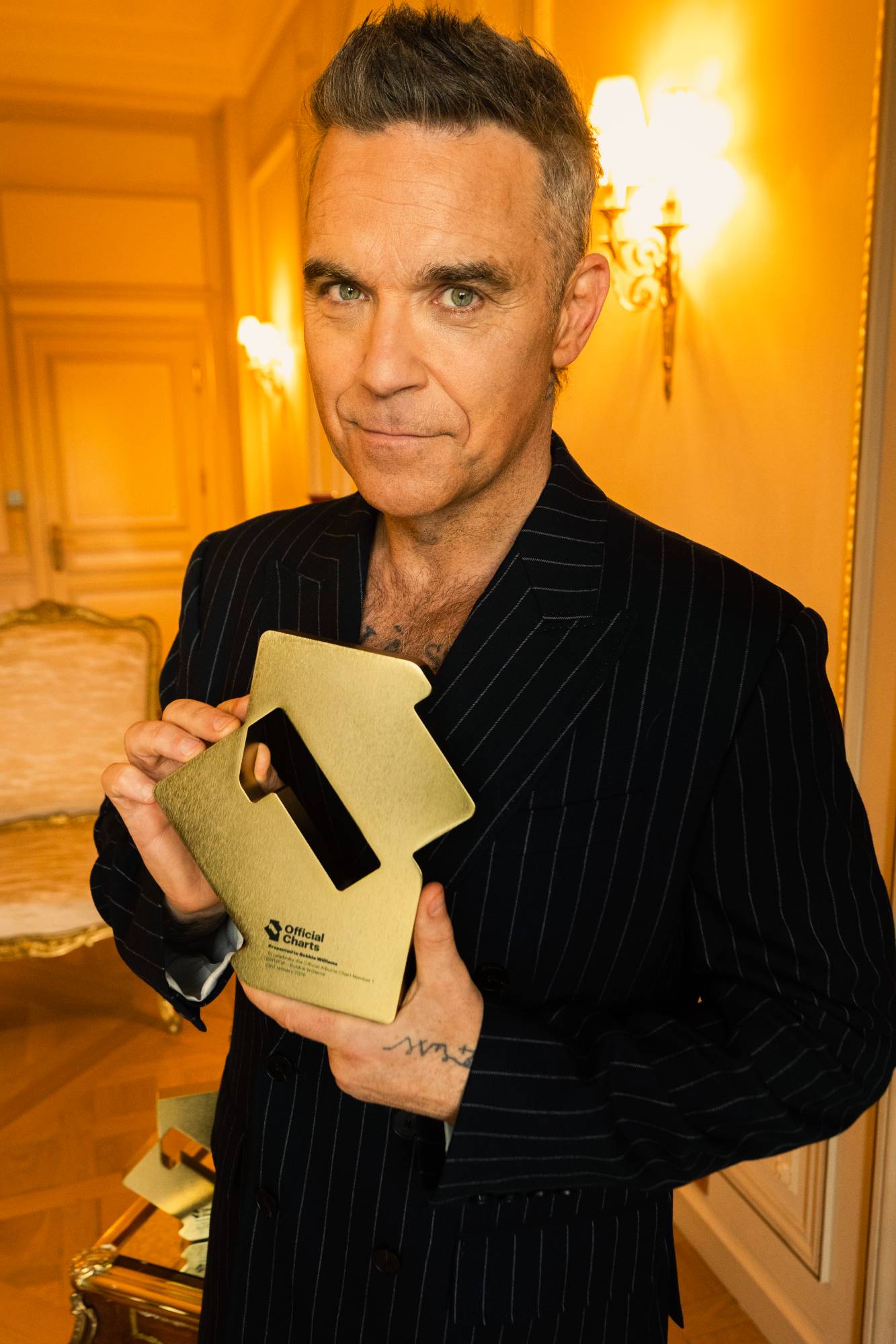 Robbie Williams celebrates scoring a record-breaking run of Number One albums in the UK. Credit: Press/Robbie Williams