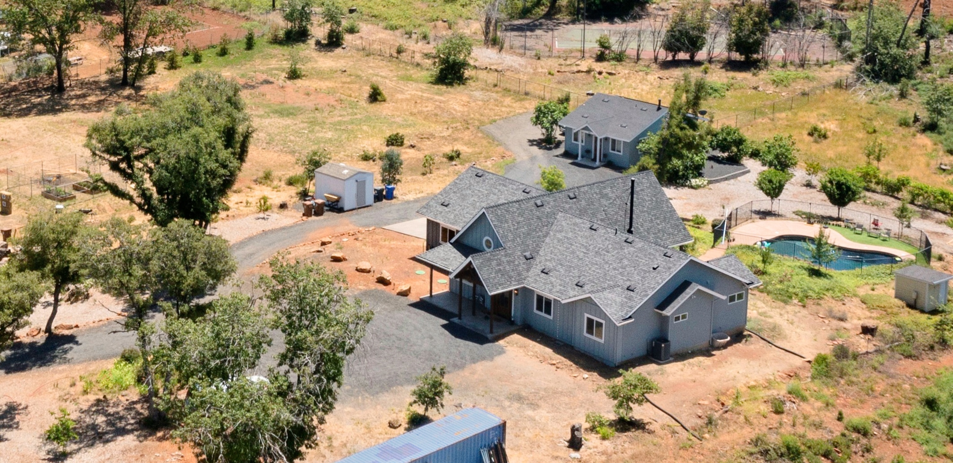 Arial view of a large house with the pond on its backyard.