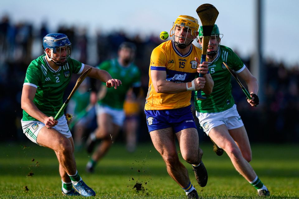 Mark Rodgers of Clare in action against Limerick players, from left, Vince Harrington and Darragh Langan. Photo by John Sheridan/Sportsfile