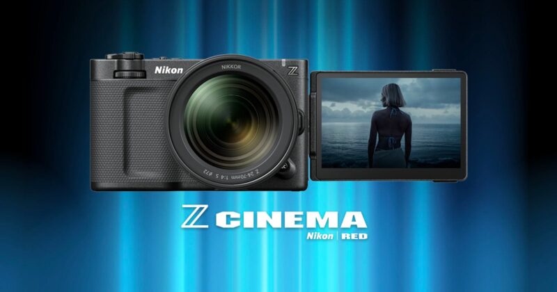 A Nikon camera with a large lens and a flip-out screen displaying a person standing by the sea, with “Z CINEMA Nikon RED” text below on a blue gradient background.