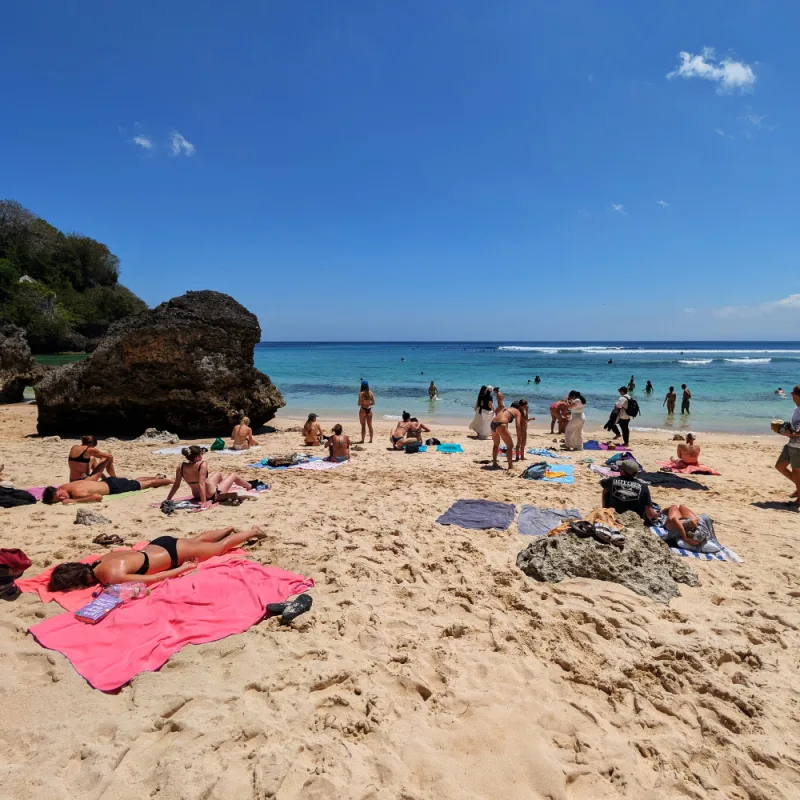 Tourists Sunbathe On Beach in Uluwatu Bali