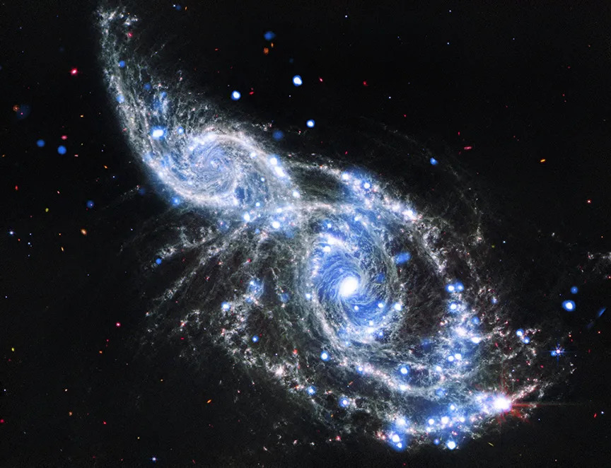Two blue and white spirals of light are intertwined in the darkness of space