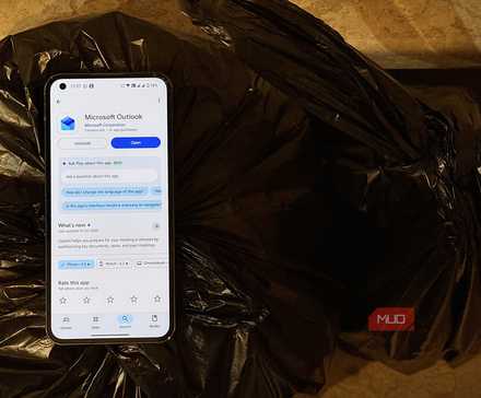 A smartphone on a bag of trash with the Microsoft Outlook app on the display