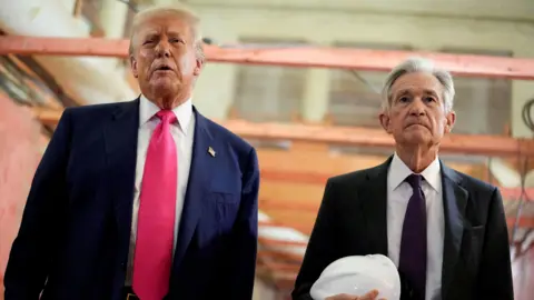 Reuters Donald Trump appears next to Jerome Powell, who is carrying a white hard hat, during a visit to the Federal Reserve building as it undergoes renovations.