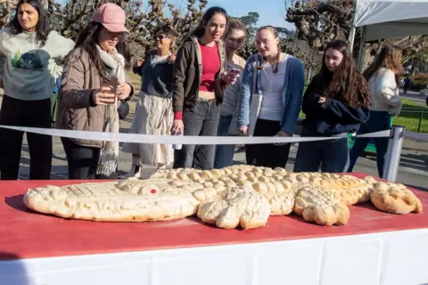 Heidi Alletzhauser/California Academy of Sciences Press Office a long white alligator-shaped sourdough bread sitting on a table