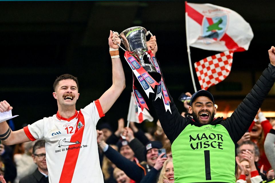 An Ghaeltacht captain PJ Mac Láimh, left, lifts the cup with the injured captain Franz Sauerland after their side's victory in the AIB GAA Football Intermediate Club Championship final match between An Ghaeltacht of Kerry and Glenullin of Derry at Croke Park in Dublin. Photo by Piaras Ó Mídheach/Sportsfile