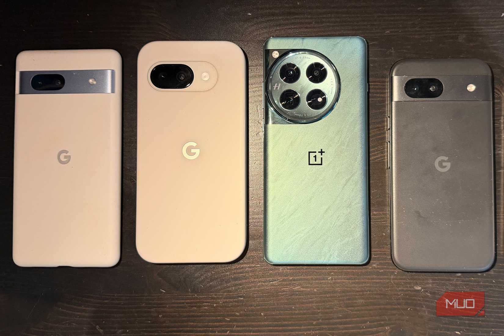 Four Android phones in a row on a table.