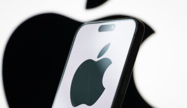In this photo illustration, the logo of Apple Inc. is displayed on a smartphone screen, with the company's iconic black apple symbol visible in the background.