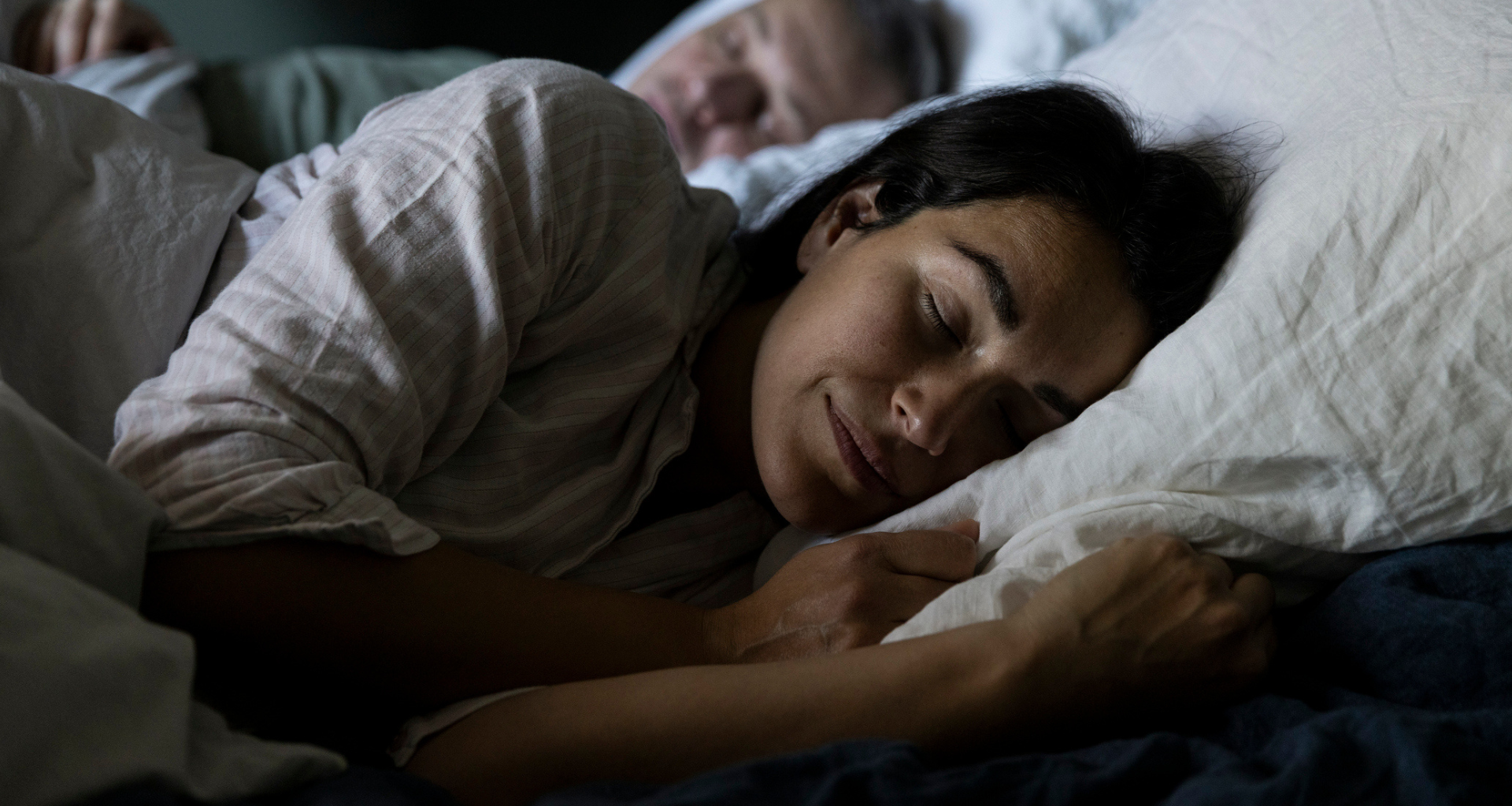 A man and woman sleeping in bed in winter