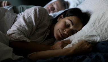 A man and woman sleeping in bed in winter