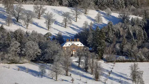 Walter Baxter A snowy view of an 18th Century mansion in the Borders surrounded by trees
