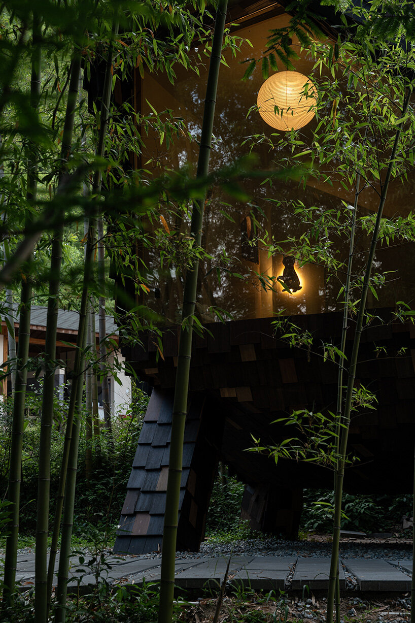 patchwork exterior of 'cat house' in china's anji forest is clad in discarded bamboo tiles