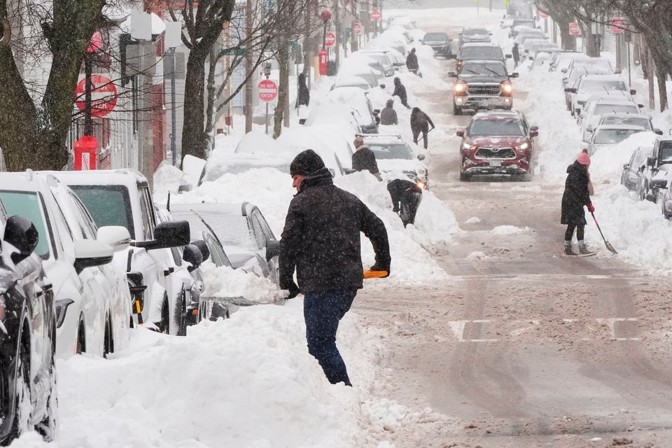Residents dig out their cars in the South Boston neighborhood following a winter storm that dump more than a foot of snow across the region, Monday, Jan. 26, 2026, in Boston. (AP Photo/Charles Krupa)