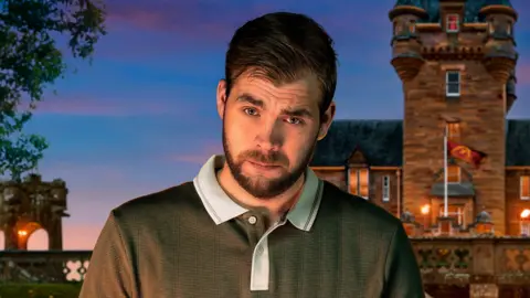 Cody Burridge/BBC/Studio Lambert Adam is in the middle. He has short brown hair and a beard and is wearing a khaki polo shirt. He is stood in front of a castle. 